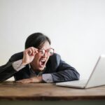yelling formal man watching news on laptop