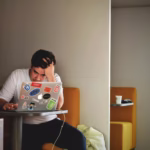 man in white shirt using macbook pro